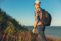 Young man, goes on a hike, with a backpack, Smiling man goes up the mountain, travel Lifestyle, summer vacation outdoors