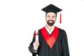 Young man in graduation hat holding diploma and looking at camera Royalty Free Stock Photo