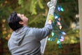 Young man in gray climbing a ladder to decorate for christmas Royalty Free Stock Photo