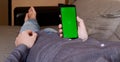 A young man in a gray shirt lying on a sofa and using a smartphone with a vertical Royalty Free Stock Photo