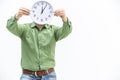 Young man in green is waiting, holding clock in front of his face over white background. Royalty Free Stock Photo