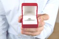 Engagement / marriage / wedding proposal scene. Close up of man handing the expensive gold platinum diamond ring to his bride. Royalty Free Stock Photo