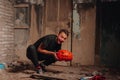 A young man in the guise of a demon on the holiday of Halloween holds a terrible pumpkin in his hands. Royalty Free Stock Photo