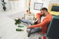 Young man with guitar sleeping near sofa in room after party Royalty Free Stock Photo