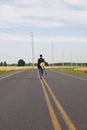 Young man with guitar walking down middle of Road Royalty Free Stock Photo