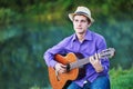 Young man guitarist playing acoustic guitar outdoors Royalty Free Stock Photo