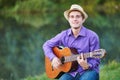 Young man guitarist playing acoustic guitar outdoors Royalty Free Stock Photo