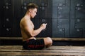 Young man at gym dressing room. Handsome guy at fitness studio doing their own staff before training. Royalty Free Stock Photo