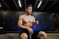 Young man at gym dressing room. Handsome guy at fitness studio doing their own staff before training. Royalty Free Stock Photo