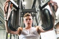 Young man in gym working out, using weights machine. Royalty Free Stock Photo