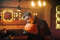 Young man in a Halloween costume of Count Dracula holds a carved festive pumpkin