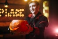 Young man in a Halloween costume of Count Dracula holds a carved pumpkin