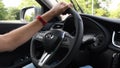 Young man hand hold steering wheel Infiniti QX50 while driving by highway