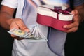 Young man hand holding gift box and cash. Royalty Free Stock Photo