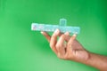 young man hand holding pill box on green background Royalty Free Stock Photo