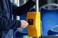 Young man hand inserts the bus ticket into the validator, validating and ticking Royalty Free Stock Photo