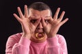 Young man with hand over eyes and a ring bagel in his mouth Royalty Free Stock Photo