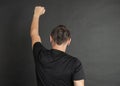 Young man with hand raised up protest gesture back pose