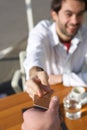 Young man handing a waiter payment card at restaurant Royalty Free Stock Photo