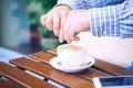 Young man hands holding sugar bag and sweetens coffee in a cafe. Royalty Free Stock Photo