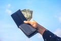 Young man hands showing dollar bills . dollar bills on sky background. Royalty Free Stock Photo