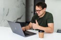 Young man has video call conference in morning at home. Smiling businessman eating breakfast and talking with girlfriend using Royalty Free Stock Photo