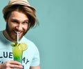 Young man in hat drinking margarita cocktail drink juice happy looking at camera Royalty Free Stock Photo