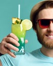 Young man in hat and red sunglasses hold margarita cocktail drink juice happy cheers Royalty Free Stock Photo