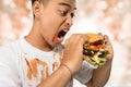 Young man have a great desire to eat a burger Royalty Free Stock Photo