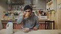A young man having breakfast in the kitchen. Man eats Corn Flakes Cereal and drinks a coffee Royalty Free Stock Photo