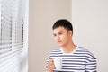 Young man having a cup of coffee while looking out of the window Royalty Free Stock Photo