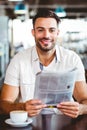 Young man having cup of coffee reading newspaper Royalty Free Stock Photo