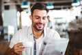 Young man having cup of coffee reading newspaper Royalty Free Stock Photo