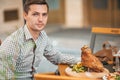 Young man having dinner in outdoor restaraunt.