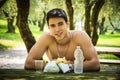 Young Man Having Fast Food Lunch at Picnic Table