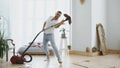 Young man having fun cleaning house with vacuum cleaner dancing Royalty Free Stock Photo