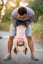 Young man having fun with little girl and hold her upside down. Royalty Free Stock Photo