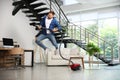 Young man having fun while vacuuming in living room Royalty Free Stock Photo