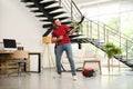 Young man having fun while vacuuming in living room Royalty Free Stock Photo