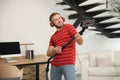 Young man having fun while vacuuming in living room Royalty Free Stock Photo