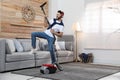 Young man having fun while vacuuming Royalty Free Stock Photo