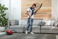 Young man having fun while vacuuming Royalty Free Stock Photo