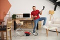 Young man having fun while vacuuming at home Royalty Free Stock Photo