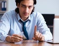 Young man having problems with narcotics at workplace Royalty Free Stock Photo