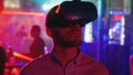 Young man in head-mounted display looks around, virtual reality, hmd 360