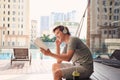 Young man with headphone near swimming pool reading book Royalty Free Stock Photo
