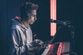 Young man in headphones behind the musical keys with a laptop. Royalty Free Stock Photo