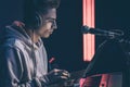 Young man in headphones behind the musical keys with a laptop. Royalty Free Stock Photo