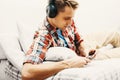 Young man in headphones with mobile phone relaxing home Royalty Free Stock Photo