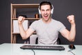 Young happy man with headset playing and winning computer game at home Royalty Free Stock Photo